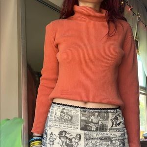 Orange ribbed knit turtleneck sweater